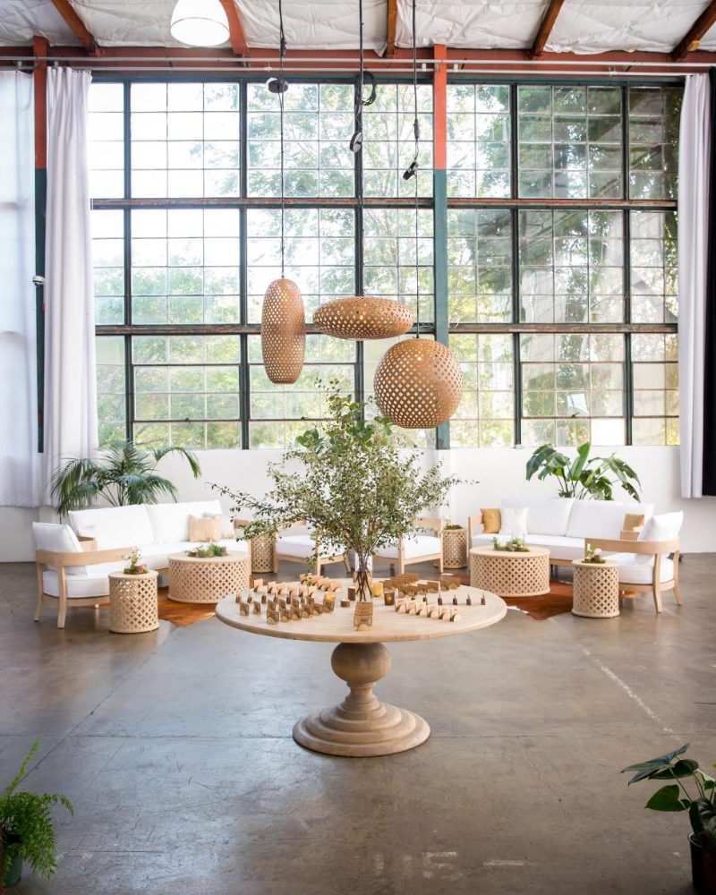 Lounge furniture and rattan pendants in a sunlit event space