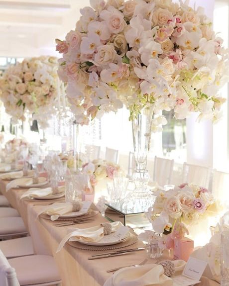 Blush rose and orchid centerpieces on a long reception table