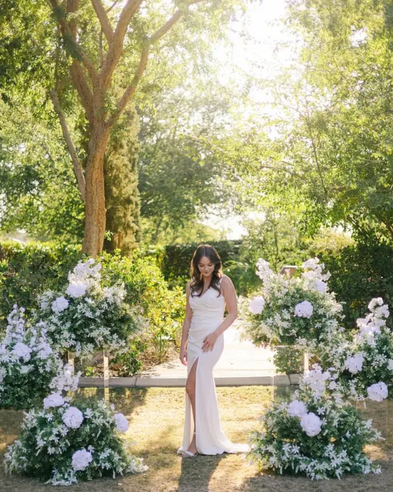 Bride standing between white floral pedestal arrangements